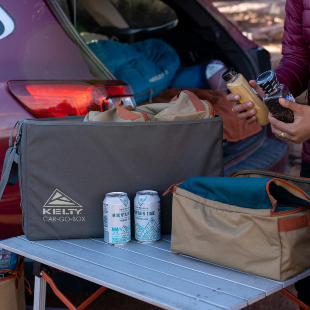 Kelty Car-Go-Box, sitting on camp table near an SUV