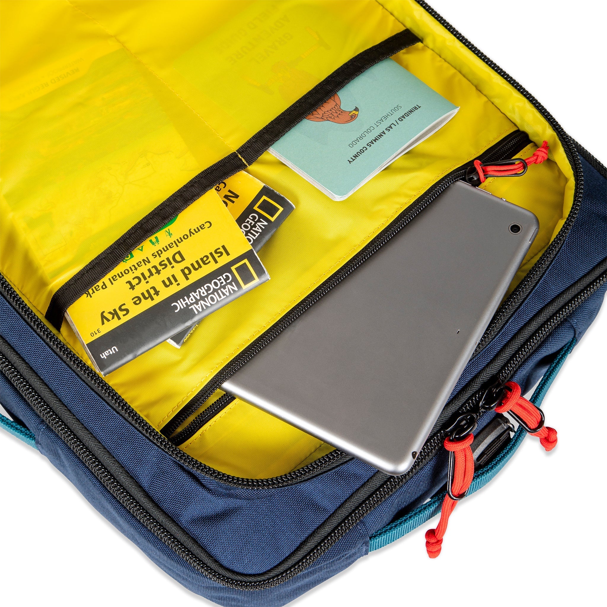 Yellow interior pockets of Topo Designs Global Travel Bag 30L Durable Carry On Convertible Laptop Travel Backpack in Navy blue.