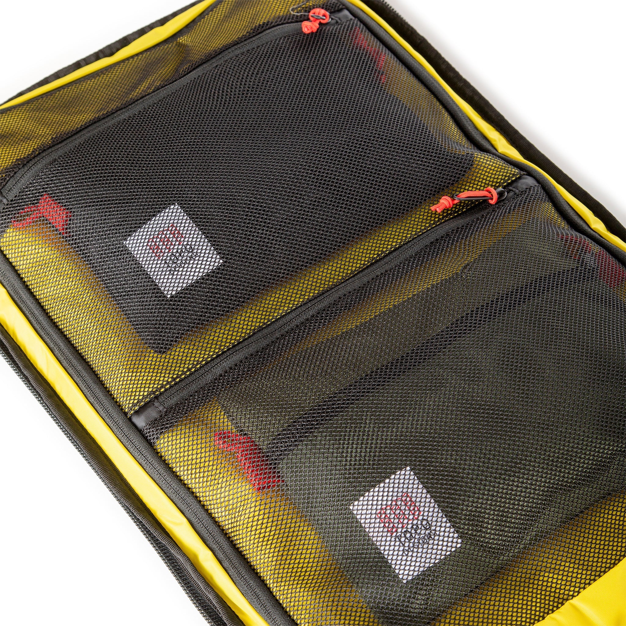 Yellow interior mesh zipper pockets of Topo Designs Global Travel Bag 40L Durable Carry On Convertible Laptop Travel Backpack in Navy blue.