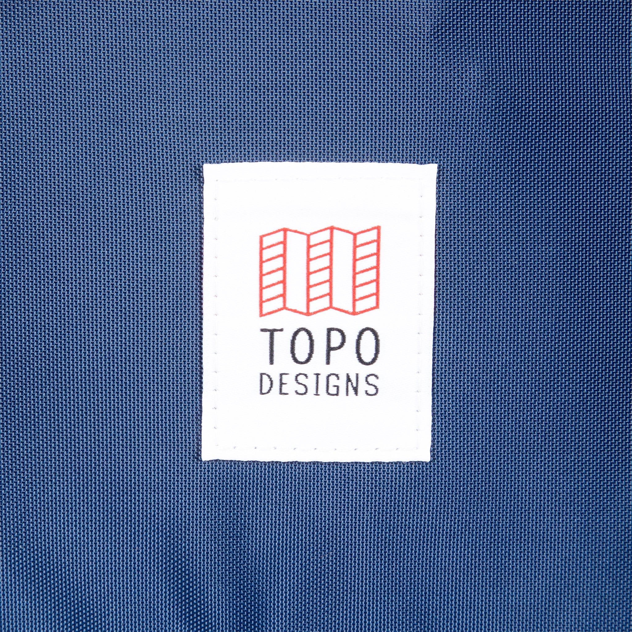Topo Designs logo patch on Global Travel Bag 40L Durable Carry On Convertible Laptop Travel Backpack in Navy blue.