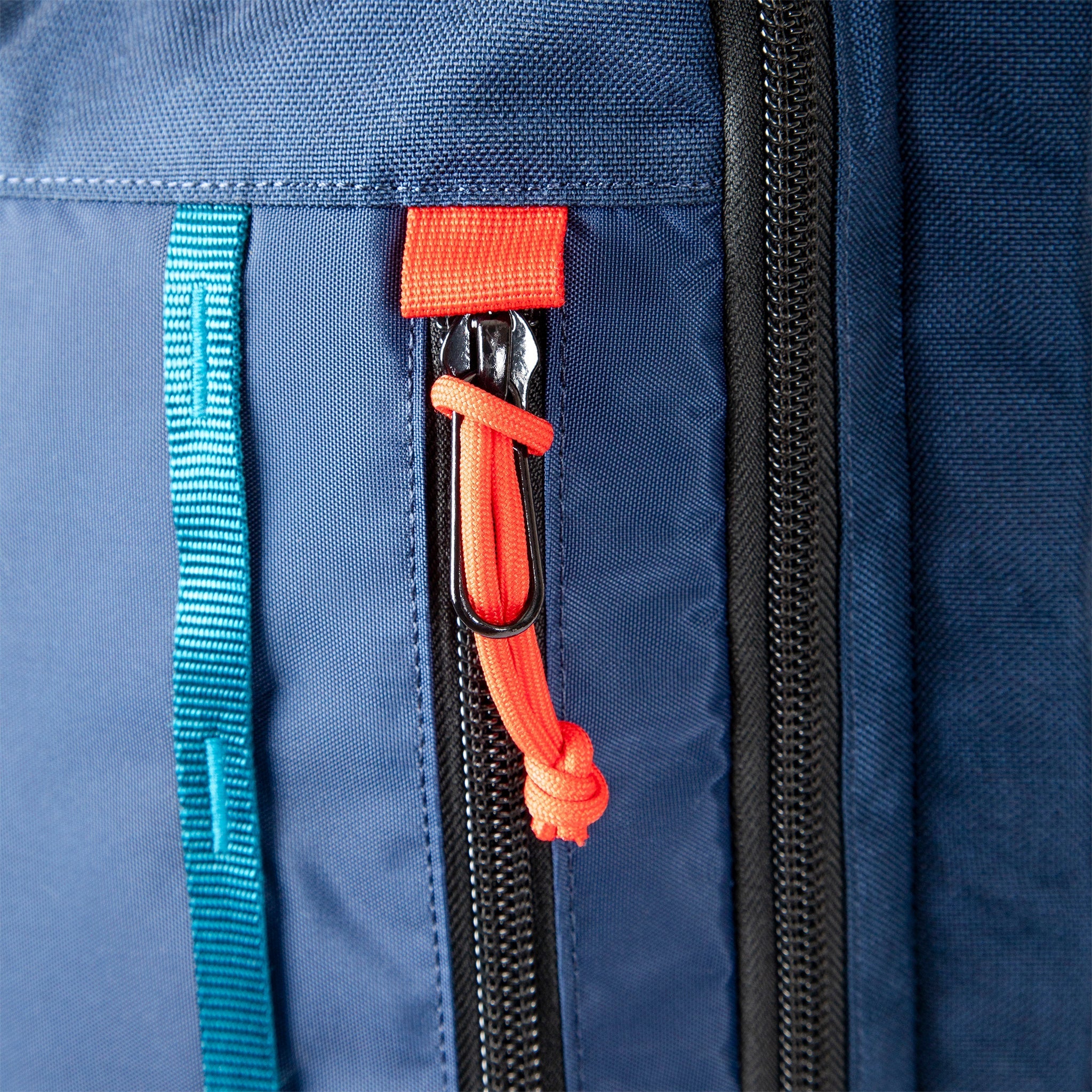 Topo Designs Global Travel Bag 40L Durable Carry On Convertible Laptop Travel Backpack in Navy blue showing daisy chain webbing and zipper pulls.