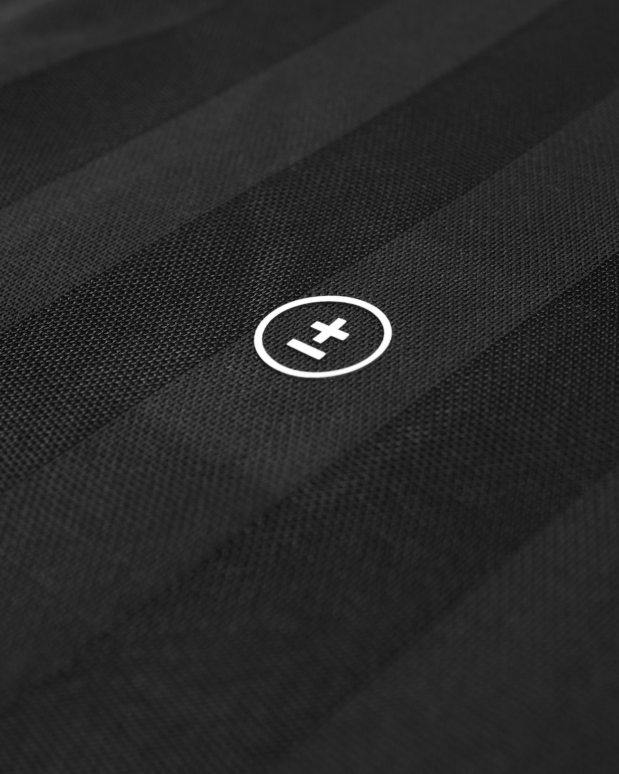 Close-up of a black fabric with a white logo on a black background