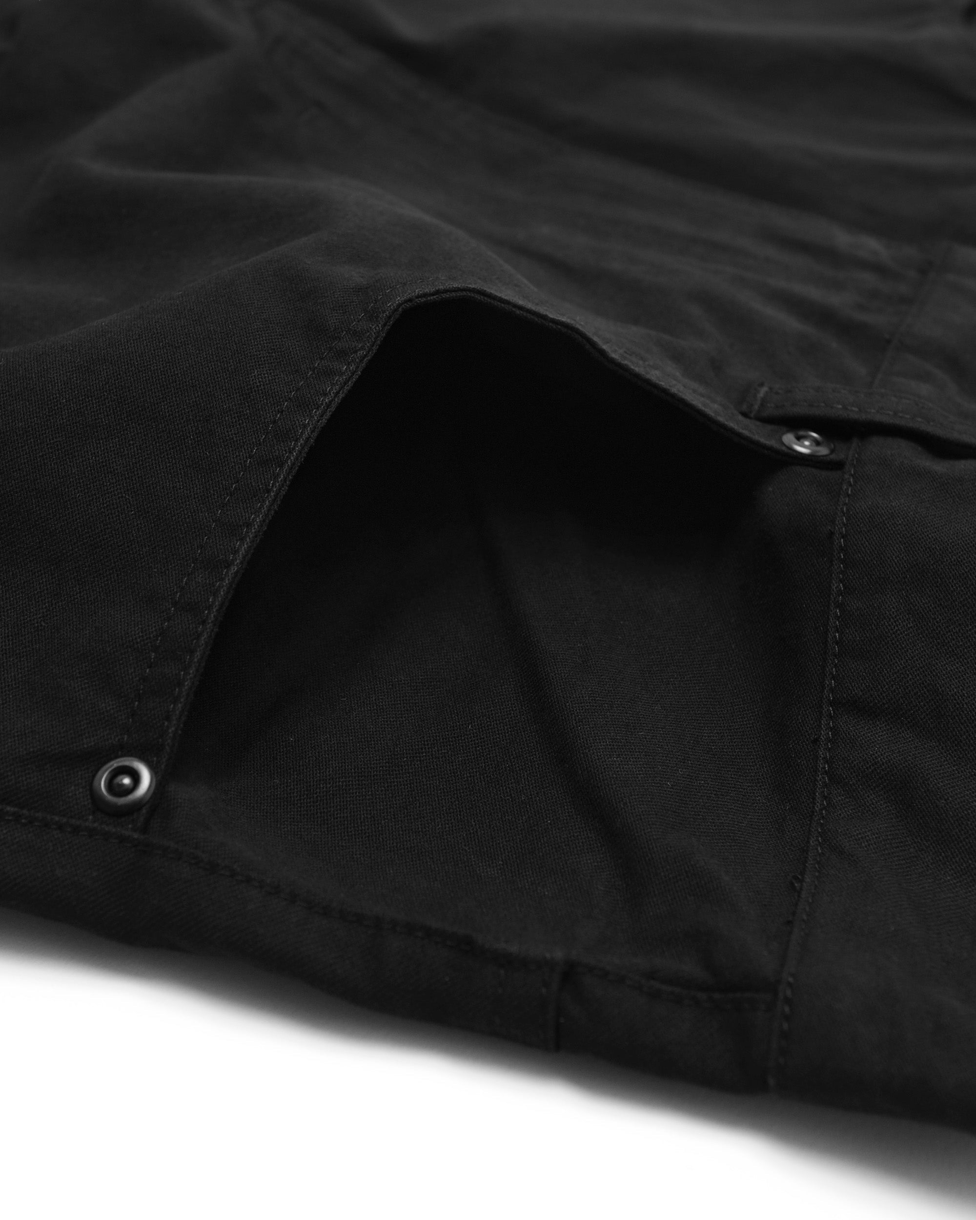 Close-up of a black pant with a pocket on a white background