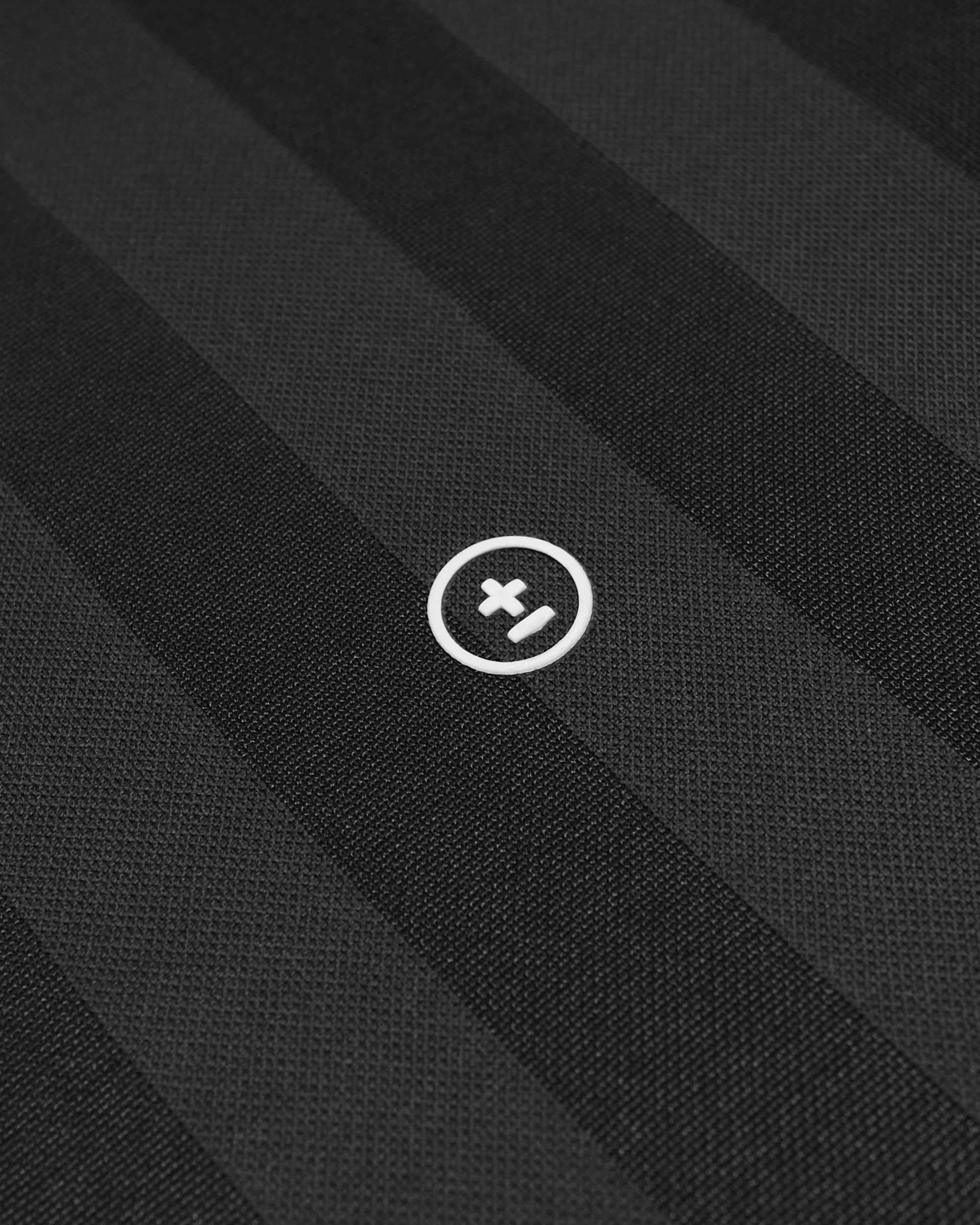 Close-up of black fabric with a white logo on a black background