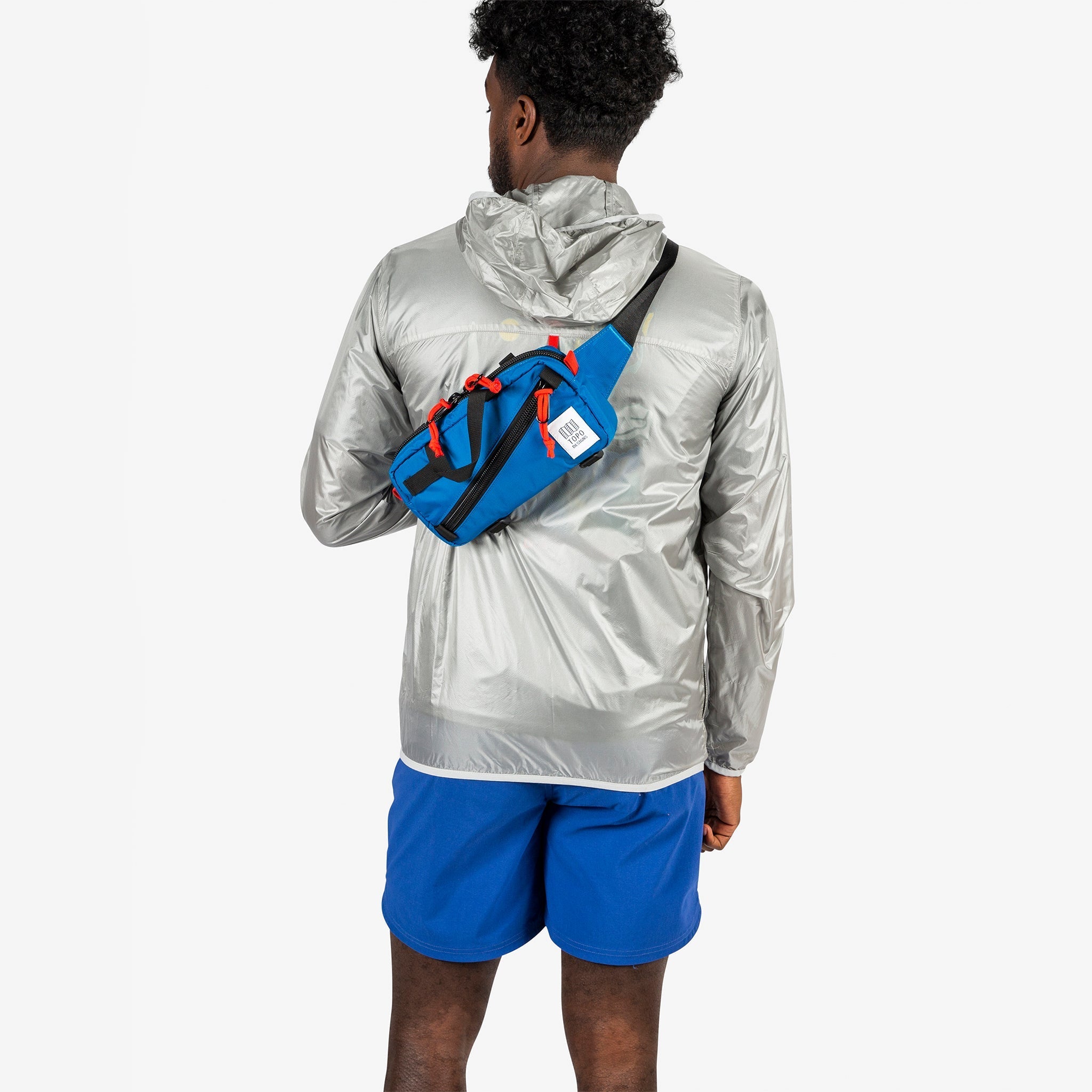 Topo Designs Mini Quick Pack in Blue worn crossbody on model.