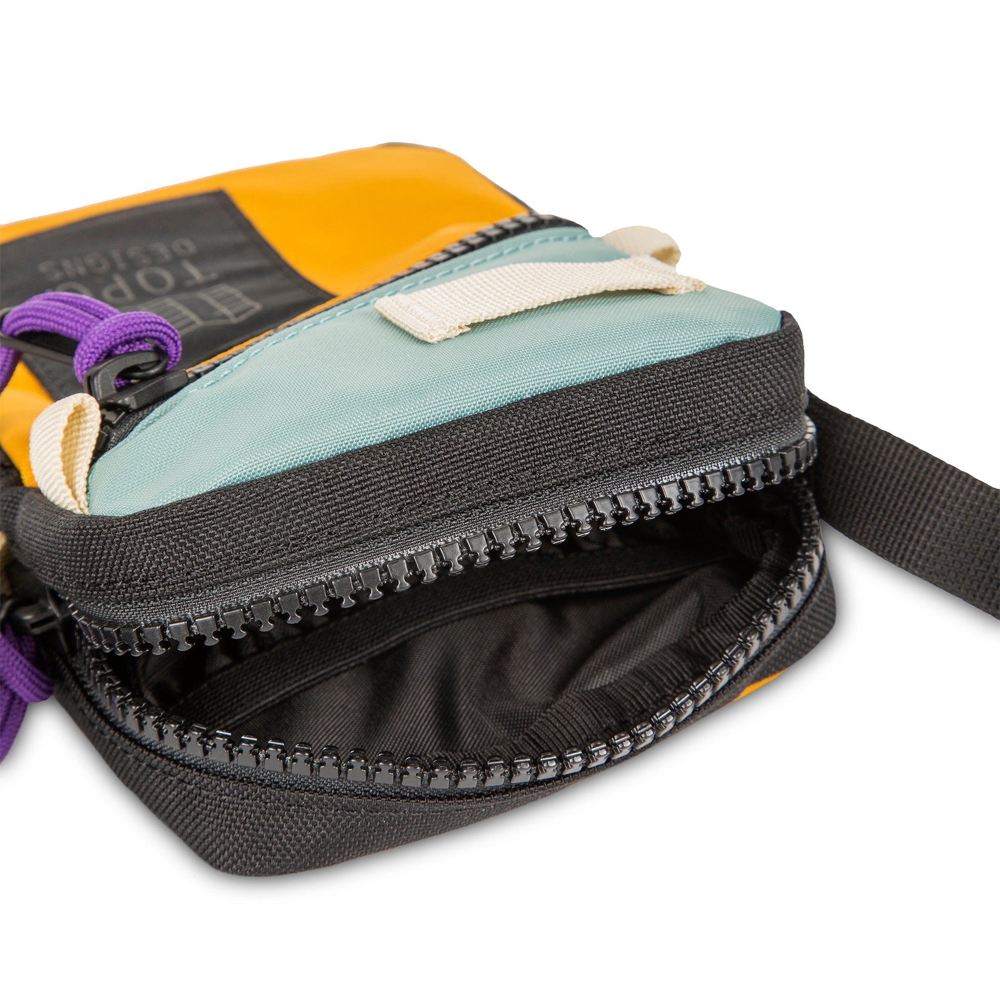 Topo Designs Mini Shoulder Bag crossbody travel purse in Sage Mustard detail showing zipper opening with black lining inside.