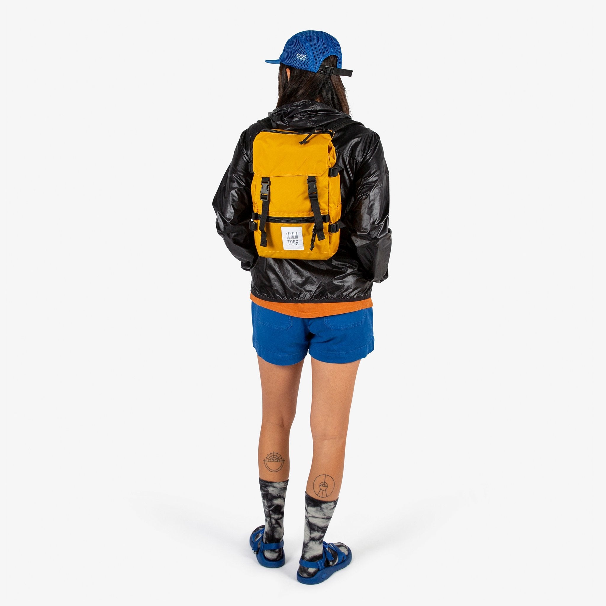 Topo Designs Rover Pack Mini backpack in Mustard yellow worn by model with backpack straps.