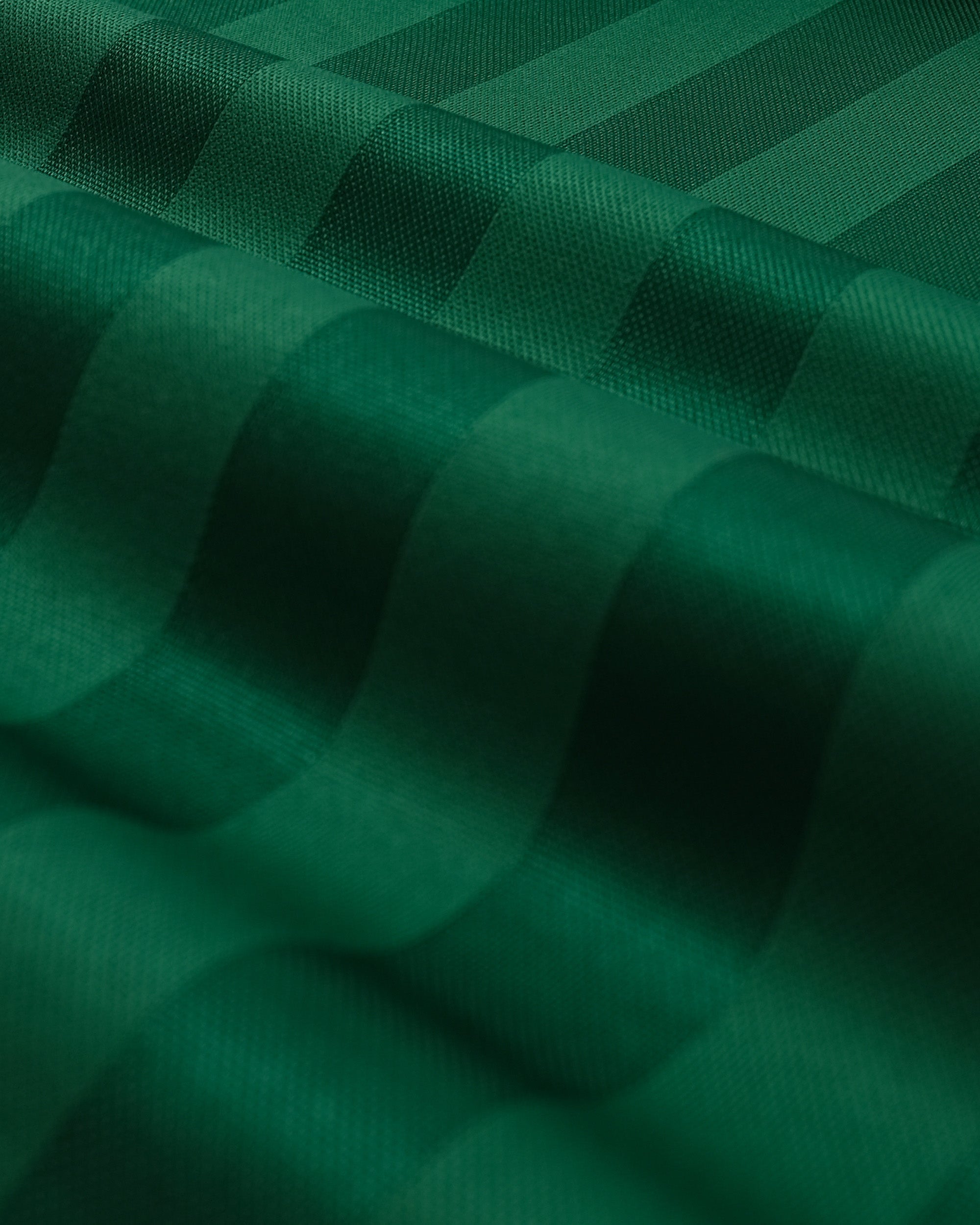 Close-up of green quilted fabric with a diamond pattern