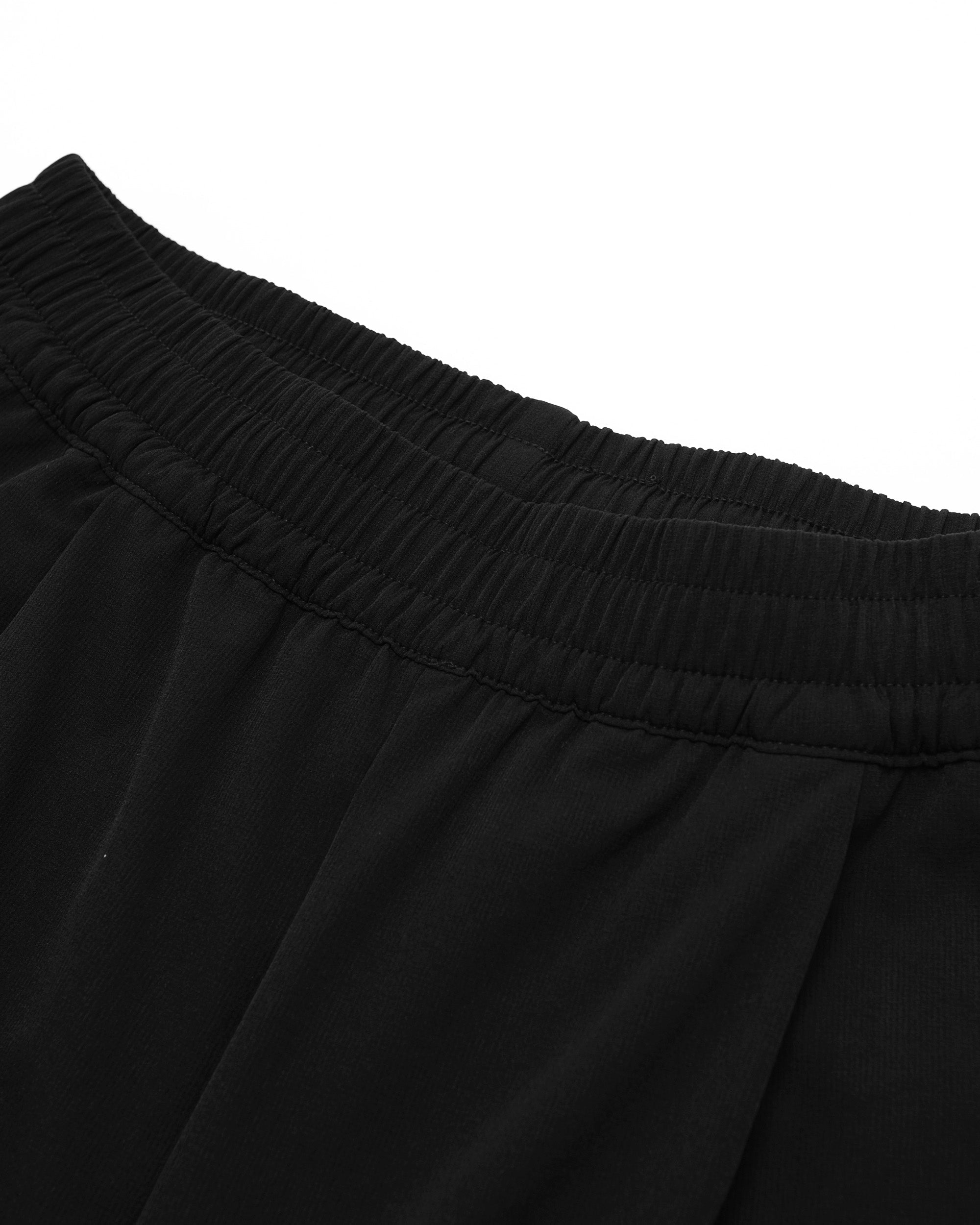 Close-up of black pants with a white background