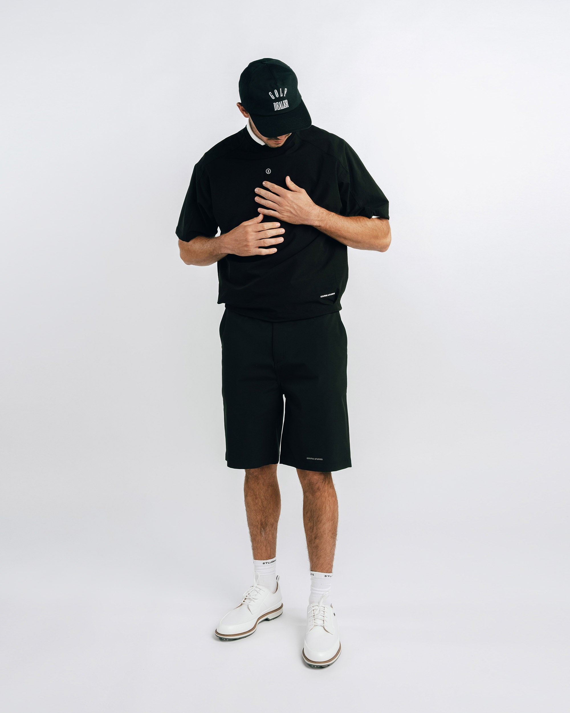 Person wearing a black outfit with a cap on a white background