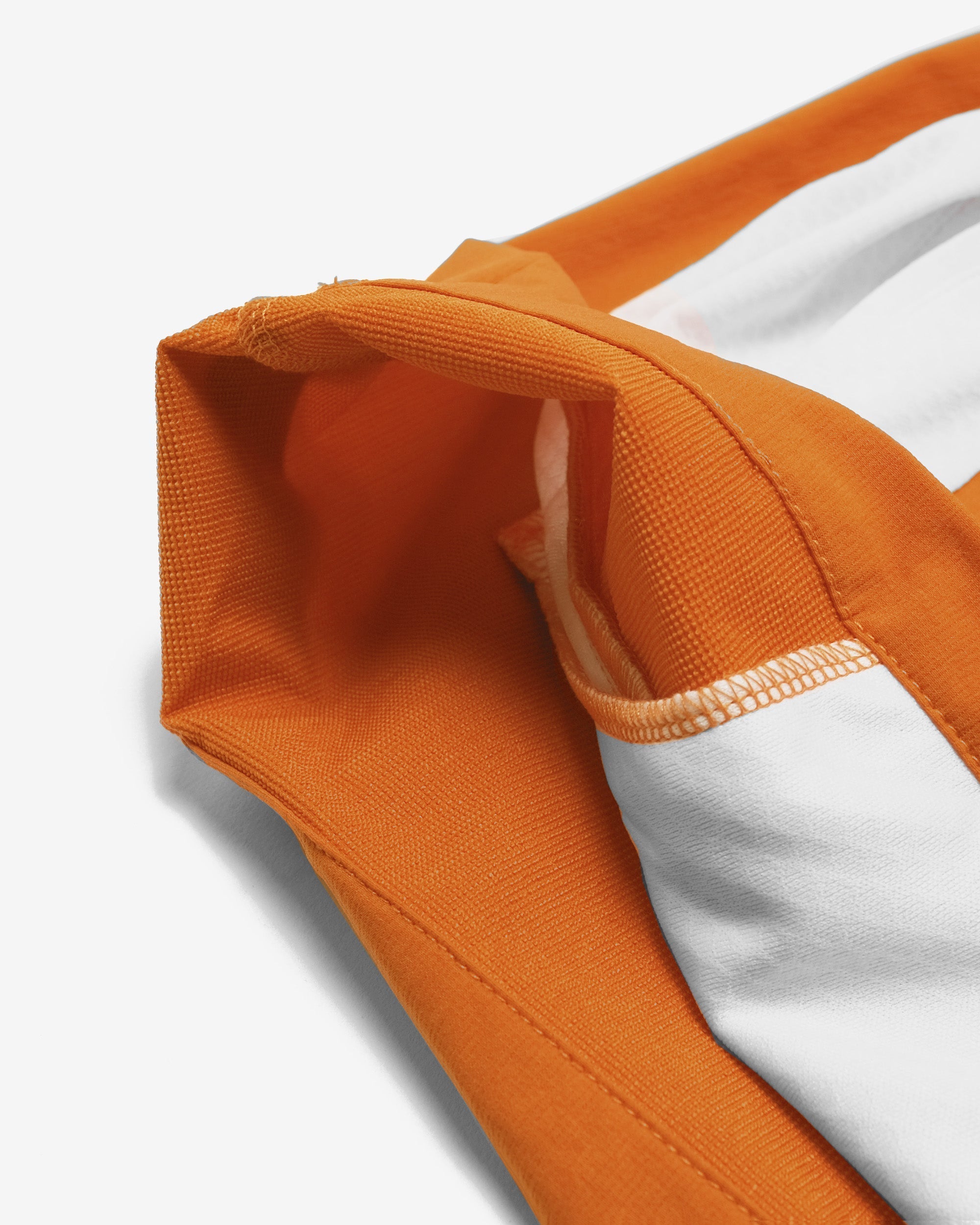 Close-up of an orange and white garment with a textured fabric.